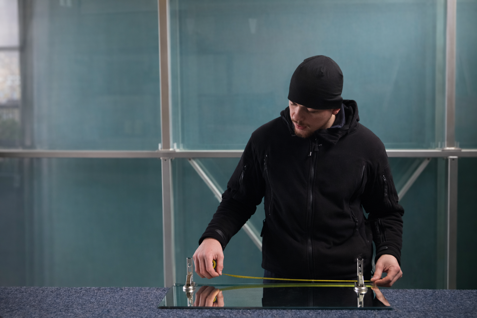 Prise de mesures à l’atelier par un vitrier.