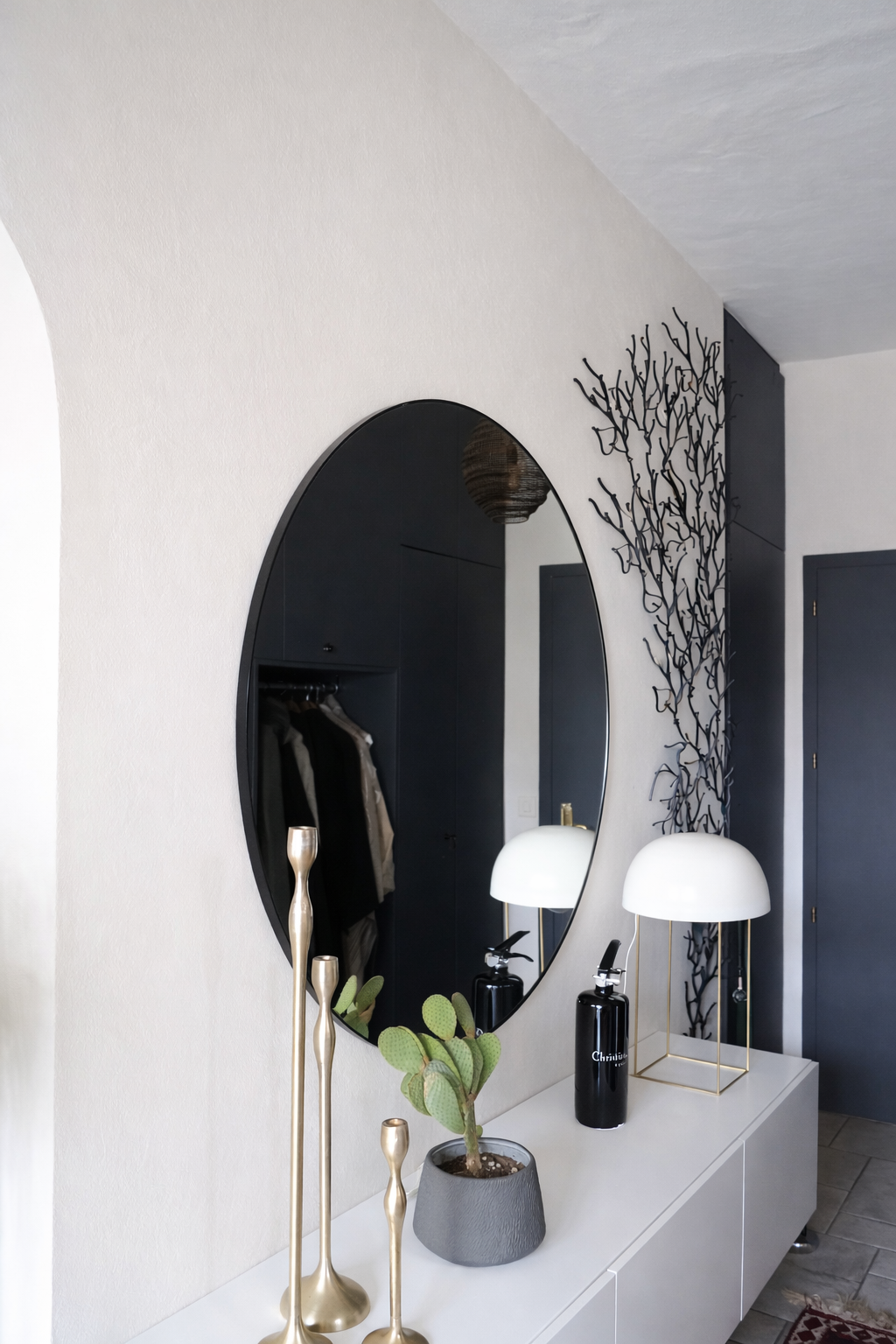Miroir rond mural design installé dans une entrée moderne avec mobilier minimaliste.